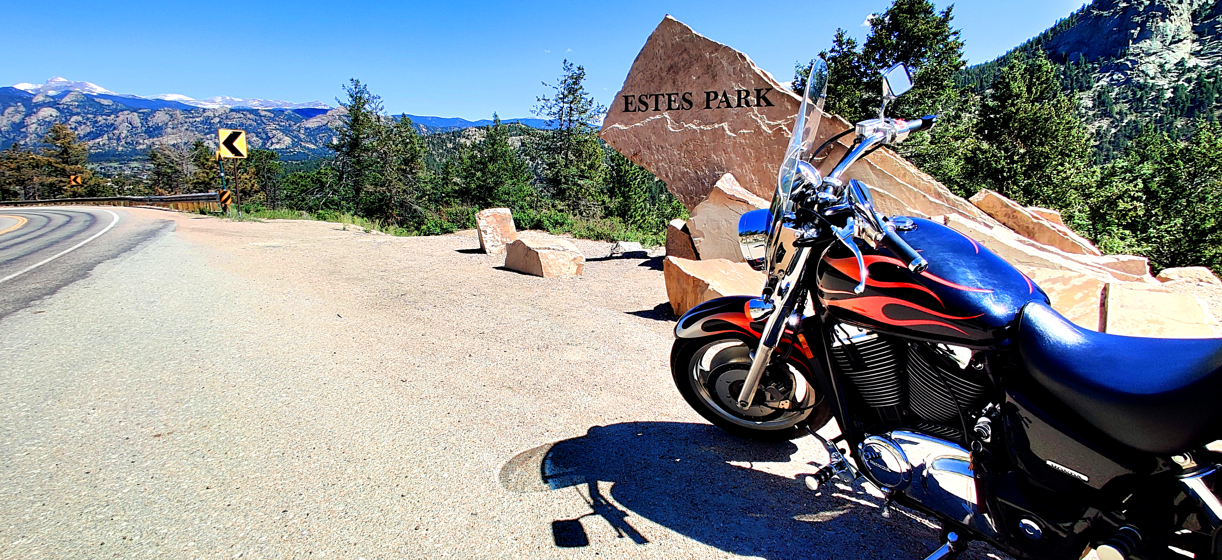 A black Honda Shadow 1100 motorcycle with flames in front of Estes Park