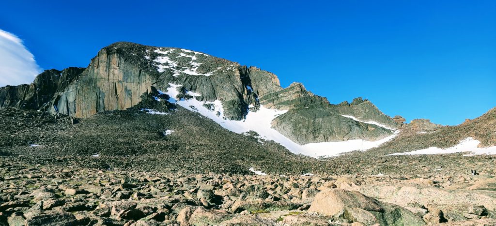 Longs Peak in summer, still covered in snow Beneath a blue sky