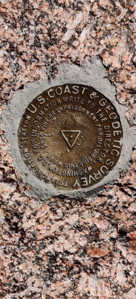A close-up of the US Geodetic Survey marker for Longs Peak at the summit. 
