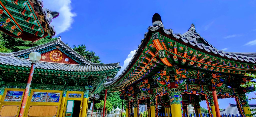 two buddhist temple structures (a Jonggo and a Pagoda)explode with color at the Mangisa buddhist temple in south korea