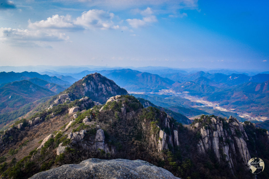 a prominent mountain stretches upwards to the sky with very few clouds and views for hundreds of miles in south korea