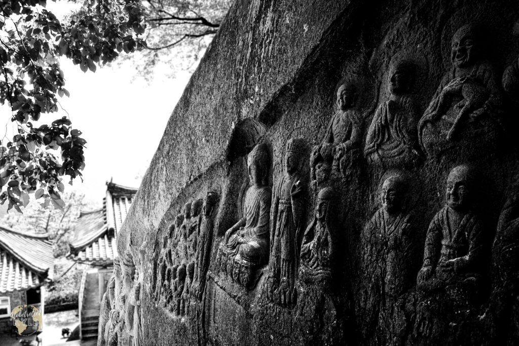 many buddha statues carved in a rock face at Byeongpungam Seokbulsa Temple