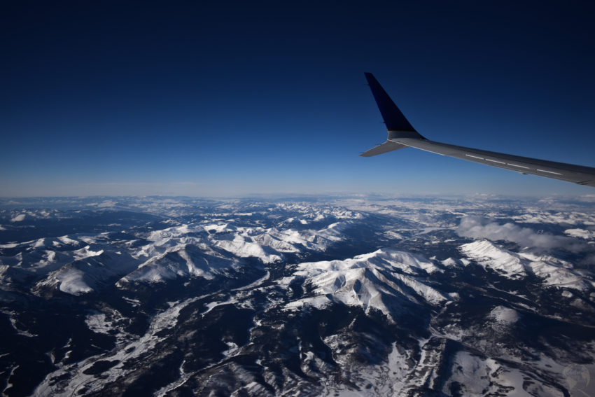 White mountains seen from the window of an airplane rocky mountains airplane wing