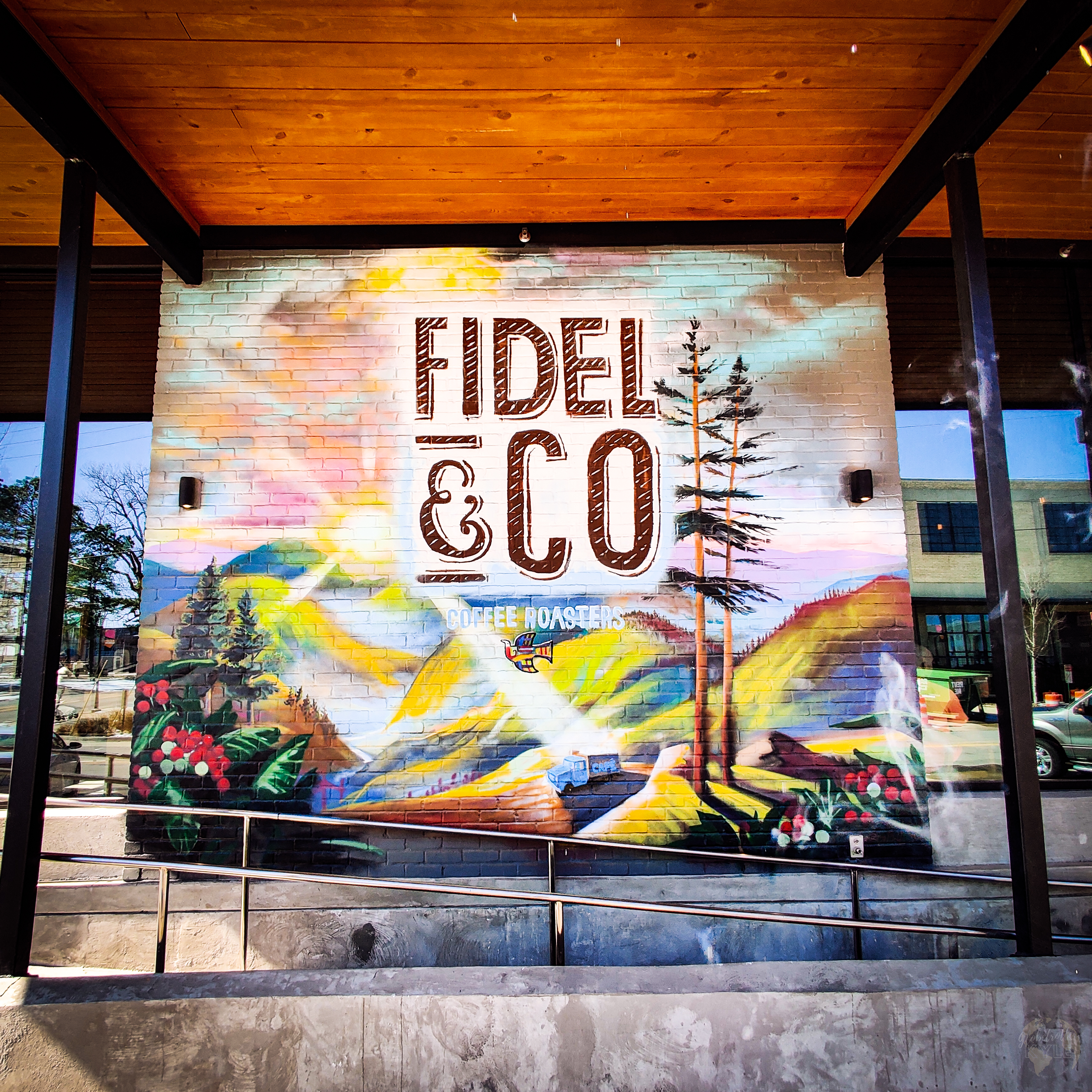 a bright colored mural with mountains trees and hills for Fidel & Co coffee roasters in little rock arkansas