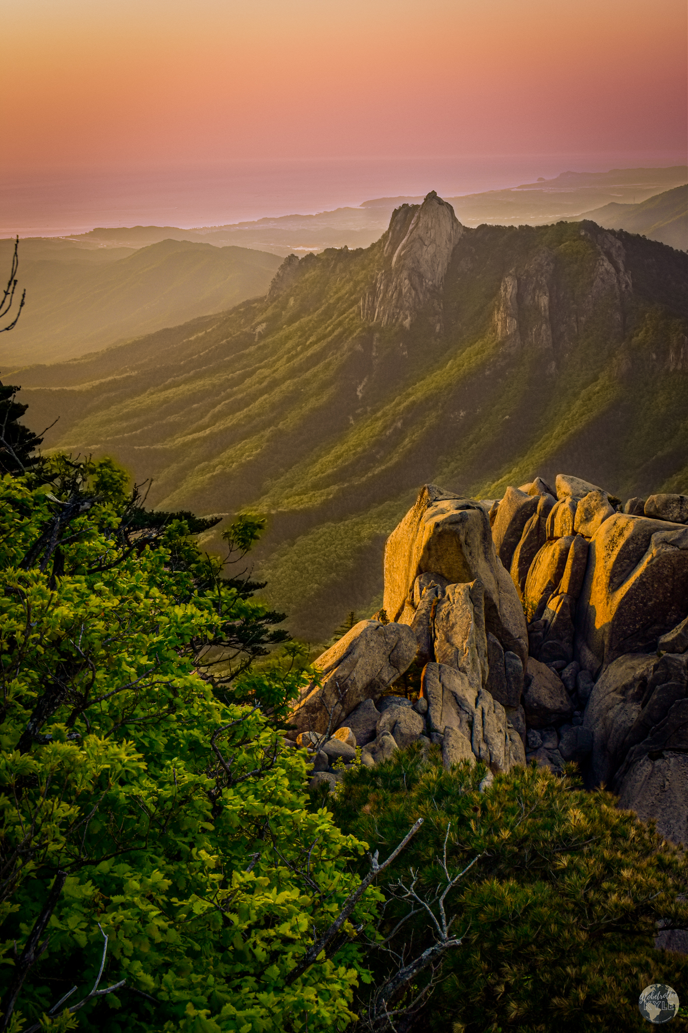 A redish glow from the sunrise forms over the Tabaek mountains at Soraksan National Park, South Korea with the East Sea in the distance. Sunrise from Soraksan National Park, South Korea