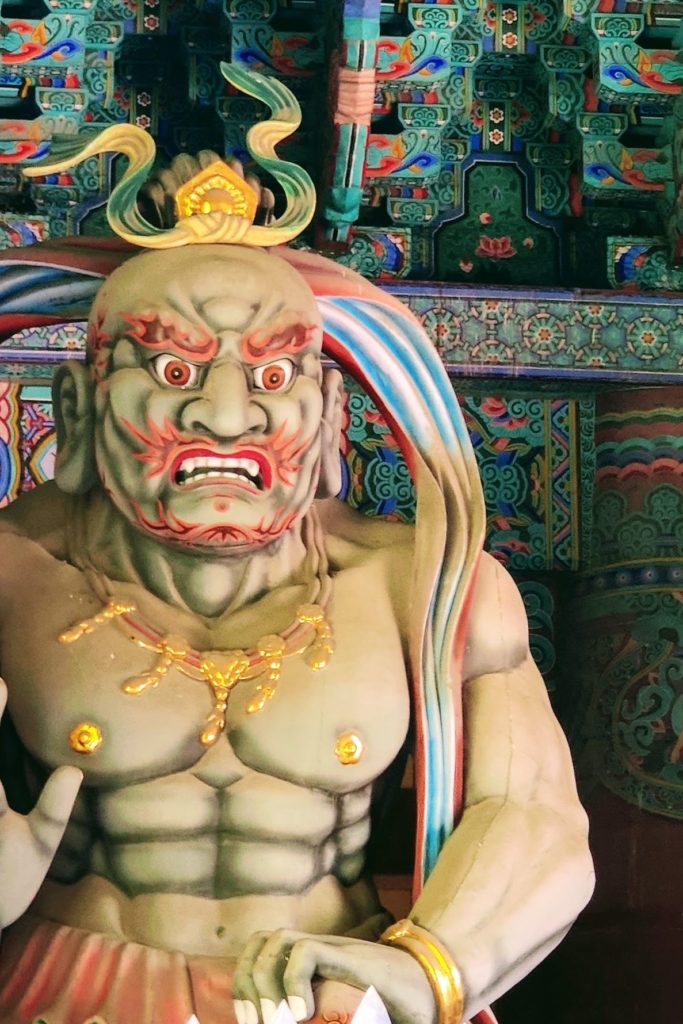 A close up image of a buddhist god known as one of the heavenly kings