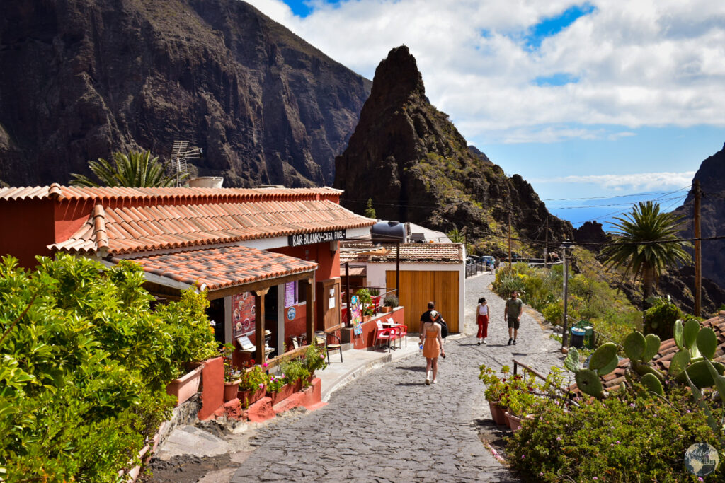 A group of people walking on a road in Masca with a mountain in the background, one of the many what to do in Tenerife items