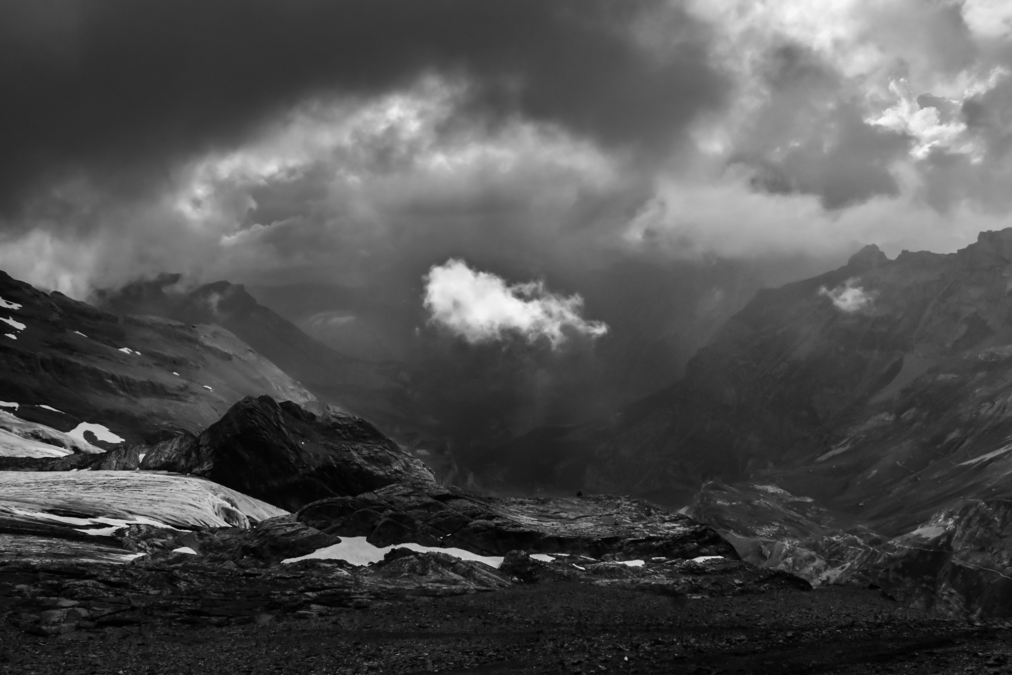 a single cloud floats between a mountain valley at eye level 