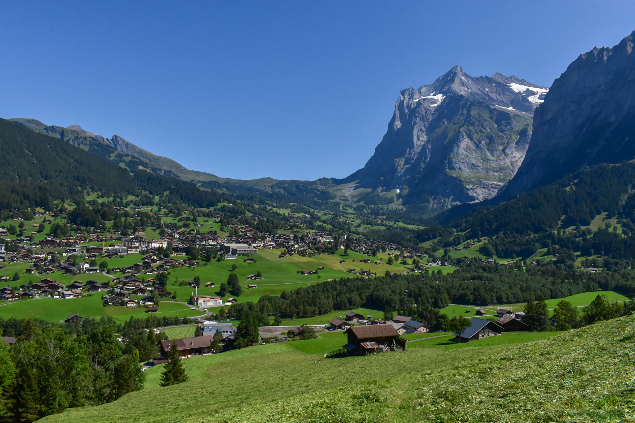 A high alpine village during summer time. It's known as Grindlewald, and  it's in the Jungfrau region of Switzerland