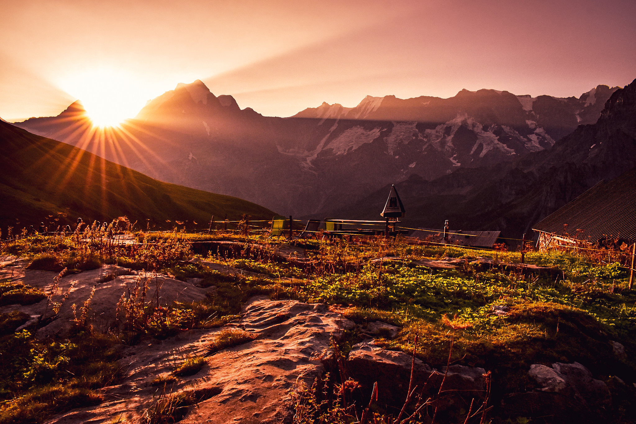 sun rays shine through the mountains near Rotstockhütte, a place to rest during a hut to hut hike in Switzerland