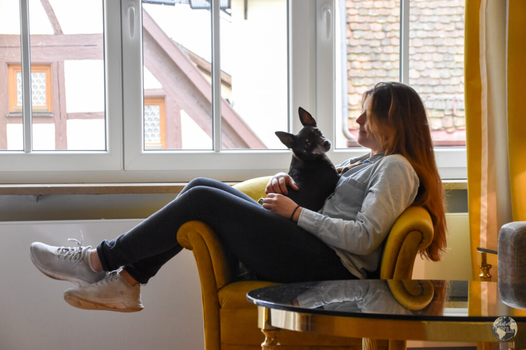 Ciara sitting in a chair with a dog inside Romantik Hotel Markusturm
