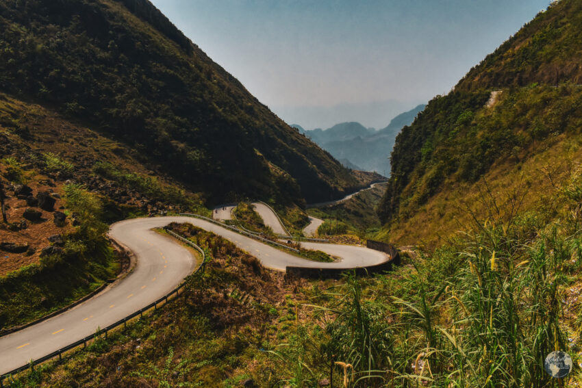 a winding road in a mountain pass ha giang loop